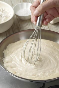 a person whisking batter into a pan on a table