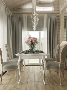 a dining room table and chairs with flowers in vases on the top of them