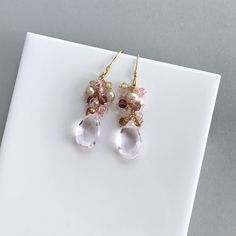 Free Shipping. Clear Rose Pink Quartz drop earrings made entirely by hand with real gemstones and 14k gold plated Italian silver. Very simple and easy to wear, these dangle earrings are perfect to throw on with anything and can be your everyday earring. They catch the light beautifully to add a hint of sparkle. STYLE DETAILS - Primary stone - Clear Pink Quartz - Gemstone Cluster - Mystic Rose Quartz, Pink Tourmaline, Champagne Quartz, Champagne Pearl - 1.5 inches long - French hooks with safety Briolette Yellow Gold Earrings For Weddings, Yellow Gold Briolette Earrings For Wedding, Elegant Wedding Cluster Earrings With Gemstones, Pink Gemstone Accented Earrings For Weddings, Pink Gemstone Earrings For Wedding, Fine Jewelry Crystal Earrings For Wedding, Pink Gemstone Wedding Earrings, Fine Jewelry Briolette Earrings For Wedding, Pink Wedding Earrings With Gemstone Accents