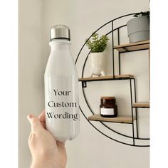 a person holding up a water bottle with the words your custom wording on it