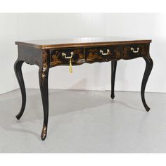 an antique black and gold desk with drawers