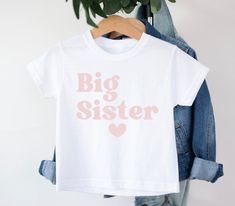 Big Sister t-shirt T-shirt is 100% Australian cotton.  We design & print our products with care & love! We use the best quality vinyls, inks & transfers on all products. * * * * * * * * * * * * * * * * * * * * * * * * * * * * * CARE INSTRUCTIONS: Wash inside out on gentle wash, Do not tumble dry. * * * * * * * * * * * * * * * * * * * * * * * * * * * * * SHIPPING: We want to get your product to you as quickly as possible, your purchase will be shipped through Australia post, Express post is available for selection. * * * * * * * * * * * * * * * * * * * * * * * * * * * * * GUARANTEE: We stand behind our products with a 100% guarantee; if you are unsatisfied with our product, please let us know & we will rectify any issues. We are unable to refund products due to change of mind or those that Unisex Family Matching T-shirt With Screen Print, White Short Sleeve T-shirt For Gender Reveal, Family Matching Unisex T-shirt With Name Print, White T-shirt With Name Print For Gender Reveal, Short Sleeve T-shirt With Name Print For Gender Reveal, Gender Reveal T-shirt With Name Print, White Letter Print T-shirt For Gender Reveal, Unisex Name Print Crew Neck T-shirt, Unisex Crew Neck T-shirt With Name Print