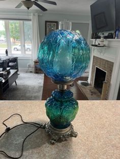 a blue lamp sitting on top of a table in a living room next to a fireplace