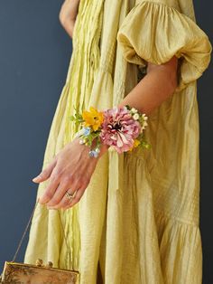 a woman in a yellow dress holding a purse