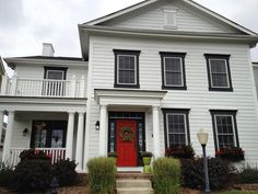 a white two story house with red front door