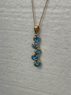 "PENDANT IS READY TO SHIP  TOPAZ JOURNEY PENDANT IN 14kt YELLOW GOLD Metal: 14KT gold Center Stone: Natural topaz Color: Blue Approximate Weight: 10ct Gram(s) weight: 3.00 grams Gemstone Size: 4MM Clarity: Eye clean-AAA grade Cut: round Size: 1 inch long app. We offer layaway payments please contact us we are flexible. ABOUT US We are a family-owned business. My name is Margarita Sciapin and I am the designer behind the jewelry we make, my husband Maxim Sciapin is the one that takes my vision and makes it a reality. Maxim is a worldwide known jeweler and diamond setter. His workmanship is often complimented in magazines and blogs, his setting style is known as: \"machine like\" for its precision and quality. We make our designs minimal and modern utilizing luxurious earth materials such as Yellow Gold Blue Topaz Pendant Jewelry, Yellow Gold Blue Topaz Pendant, Fine Jewelry Yellow Gold Topaz Gemstones, Yellow Gold Blue Topaz Gemstone Jewelry, Yellow Gold Jewelry With Blue Topaz Gemstone, Gold Blue Topaz Pendant Jewelry, Yellow Gold Blue Topaz Round Pendant, Round Yellow Gold Blue Topaz Gemstones, Yellow Gold Topaz Gemstones As Gift