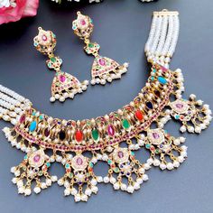 Beautifully handcrafted navrattan choker necklace in 22ct hallmarked gold along with matching earrings. The necklace weighs 55 GMs including 16.21 GMs of stringing and hanging beads. The earrings weigh 14.08 GMs including 1.05 GMs of hanging beads. Festive Multicolor 22k Gold Bridal Necklace, Ceremonial 22k Gold Multicolor Jewelry, Multicolor Cutdana 22k Gold Jewelry, Multicolor 22k Gold Cutdana Jewelry, Multicolor 22k Gold Jewelry With Cutdana, Multicolor 22k Gold Bridal Necklace For Celebration, Multicolor 22k Gold Bridal Necklace For Festivals, Traditional Multicolor 22k Gold Necklace, Traditional Multicolor 22k Gold Necklaces