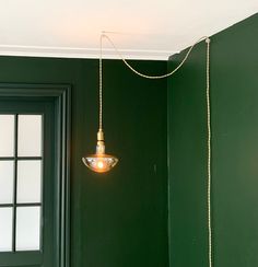 a green room with a light hanging from the ceiling