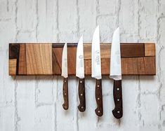 four knives are hanging on a wall