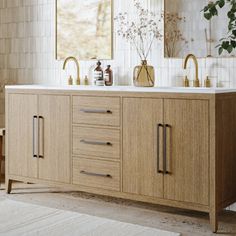 a bathroom with two sinks and mirrors on the wall next to a rug in front of it