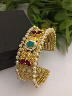 Material:  brass, Cz Stone, pearls  Stunning Gold Bracelet with Royal and Elegant look. You can wear this with any kind of outfits like Kurtis, lehanga, Sarees and Trousers and Denims. Most eligible gift for someone you love and someone very special for you. Best gift for your anniversary. Best gift for her Birthday. Bracelet : 1 Arrives in a small plastic box. For any queries please contact me. Heavy Fusion Style Bracelets For Celebration, Heavy Fusion Style Bracelet For Celebration, Fusion Kundan Bracelets With Stone Work, Fusion Style Kundan Bracelets With Cutdana, Traditional Pearl Bangle Bracelet As Gift, Traditional Pearl Bangle Bracelet For Gift, Temple Jewelry Bracelets With Stone Work For Celebrations, Gold Pearl Bracelet With Intricate Design For Wedding, Temple Jewelry Bracelets For Celebration With Stone Work