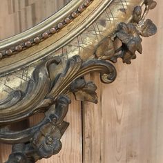 an ornate gold framed mirror on a wooden wall