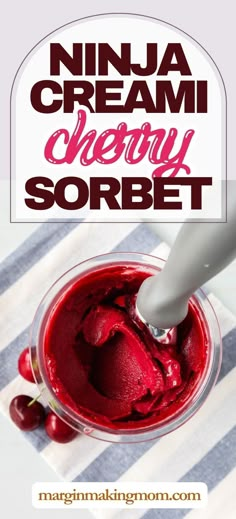 a bowl filled with ice cream and cherries on top of a striped table cloth