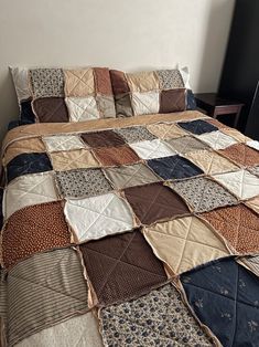 a bed covered in lots of different types of quilts