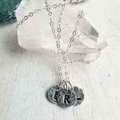 Sterling silver keepsake Initial necklace. Small circle charms are textured and stamped with the letters that mean the most to your heart. Add your initials in the order notes box at checkout. Solid sterling silver charms 1/4 wideSterling silver cable chain. Small Personalized Sterling Silver Necklace, Sterling Silver Initial Pendant Charm Necklace For Mom, Personalized Silver Charm Necklaces With Initials, Sterling Silver Hand Stamped Initial Pendant Necklace, Sterling Silver Hand Stamped Pendant Charm Necklace, Stamped Round Pendant Charm Necklace For Mom, Engraved Silver Round Disc Charm Necklaces, Silver Initial Necklace Gift For Mom, Silver Initial Necklace For Mom