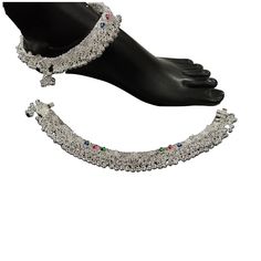 "Description This pair of bridal Pajeb anklets is crafted from 80.0% silver purity and offers superior quality and hardness with a moonlight finish. Cluster beads and light bells create a pleasant \"chann-chann-chann\" sound, perfect for those looking to add a luxurious touch to their collection. Handcrafted and not made of 80%, this silver anklet pair with cluster of beads, color Meena, and light bells offers excellent hardness, superior quality, and a moonlight finish. Price is per pair. Ankle Chan Chan, Silver Anklet, Silver Anklets, Anklet Jewelry, Body Jewellery, Anklets, Hallmark, Sound, Beads