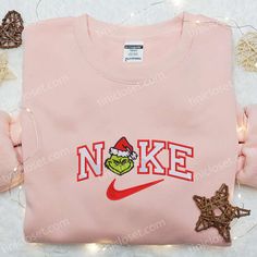 The Grinch Head x Nike Embroidered Shirt is the perfect blend of holiday cheer and street style. Made with high-quality cotton, it features a vibrant embroidered Grinch head and Nike logo, adding a festive touch to your wardrobe. The shirt’s comfortable fit and durable construction ensure long-lasting wear. Whether you’re hitting the gym or attending a holiday party, this shirt will keep you looking cool and festive. Give the gift of style this Christmas with our Grinch Head x Nike E Gingerbread Embroidery, Nike Inspired, Maroon Hoodie, Christmas Gif, Hoodie Material, Family Christmas Gifts, Embroidered Clothes, Embroidered Sweatshirt, Embroidered Hoodie