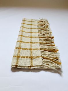 a white and yellow checkered blanket laying on top of a table