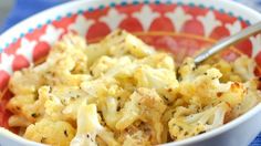 a bowl filled with macaroni and cheese on top of a blue table cloth