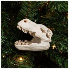 a dinosaur skull ornament hanging from a christmas tree