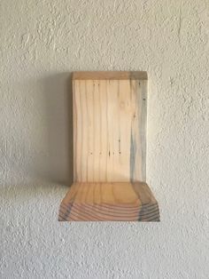 a piece of wood sitting on top of a white wall