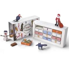 an assortment of toys in a box with numbers and figures on the front, including santa's helper