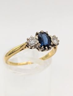 three stone diamond and blue sapphire ring in yellow gold with white diamonds on the sides