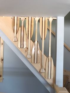 some wooden paddles are hanging on the wall next to a banister and stairs