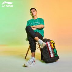 a young man sitting on a chair with his legs crossed and luggage in front of him