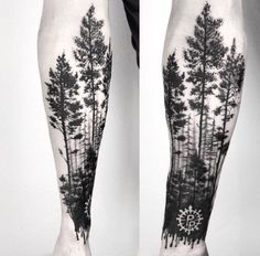 a man's leg with trees and compass tattoo on it