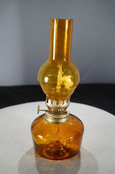 a yellow glass vase sitting on top of a white table