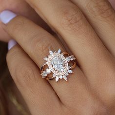 a woman's hand with a diamond ring on top of her finger and an engagement band