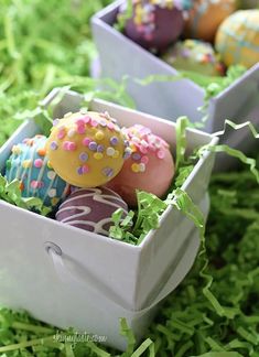 decorated easter eggs in an egg box on the grass