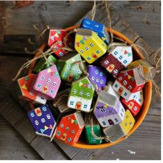 a bowl filled with colorful wooden blocks sitting on top of a wooden table next to string