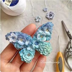 crochet flowers are being worked on by someone using scissors and yarn to make them