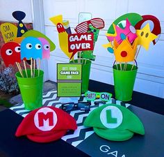 the table is set up with paper cut outs and games over hats on it, along with other decorations