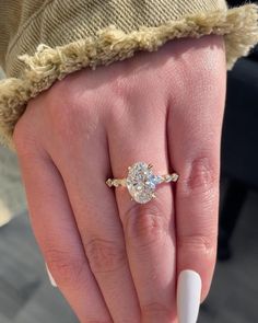 a woman's hand with a white manicured nail and a ring on it