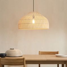 a wooden table and chair with a light hanging from the ceiling over it's head