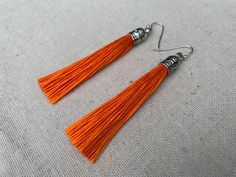 "Chic orange tassel earrings! They would add a pop of color to any outfit for any occasion. Dress them up or down. They are timeless and versatile. They are lightweight, fun and unique! The tassels measure 2 1/8\" long by 1/4\" wide. They hang from simple silver ear wire hooks. Overall drop length is about 2 1/4\". Metal is allergy free plated silver. These are my latest creation! I have them available in many colors! Find them all under the category tassel earrings in my shop. Thanks for stoppi Lover Earrings, Autumn Earrings, Orange Jewelry, Boho Hoop Earrings, Silver Chandelier Earrings, Silver Chandelier, Boho Hippie Chic, Orange Earrings, Fall Earrings