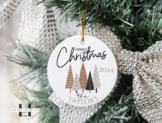 personalized christmas ornament hanging from a tree with glittery bow on it