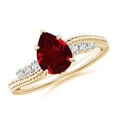 a ring with a red stone and two diamonds on the side, set in yellow gold