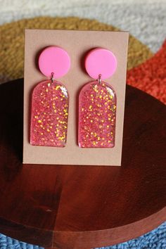 These earrings give major dollhouse energy and are perfect for any pink enthusiast. Playful Pink Earrings For Party, Pink Fun Dangle Jewelry, Playful Pink Earrings For Gift, Pink Resin Earrings For Party, Handmade Pink Earrings For Party, Fun Pink Dangle Jewelry, Fun Pink Earrings For Pierced Ears, Trendy Pink Plug Earrings As Gift, Playful Pink Resin Earrings