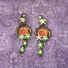 Gorgeous and very fancy vintage earrings in excellent condition!  Made of brass beads and glass with a rose print in center. Long drops approx. 3" Soft green and yellow tones combines with the vintage oxidized brass makes them one of a kind! Vintage Beaded Drop Earrings, Vintage Green Clip-on Drop Earrings, Vintage Green Flower Earrings, Vintage Gold Beaded Earrings, Vintage Handmade Green Flower Earrings, Handmade Vintage Green Flower Earrings, Vintage Handmade Green Chandelier Earrings, Vintage Green Jeweled Earrings, Fancy Earrings