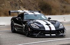 a black and white sports car driving down the road