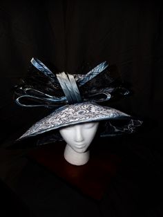 Midnight Rhapsody Derby Hat This captivating fascinator is a must-have for any sophisticated wardrobe. Its intricate design and rich color palette make it a true statement piece. Dramatic Design: A bold, eye-catching statement piece. Intricate Details: Exquisite craftsmanship and attention to detail. Rich Color Palette: A stunning combination of deep blues and blacks. Versatile Styling: Can be worn in various ways to suit your style. Perfect for Special Occasions: Ideal for weddings, galas, and other formal events. Make a Statement Today! Elevate your style with this unique accessory--shop now and turn heads at your next event! Sophisticated Wardrobe, Formal Hat, Hat Tea Party, Church Hat, Tea Party Hats, Elegant Hats, Kentucky Derby Hat, Derby Hat, Fancy Hats