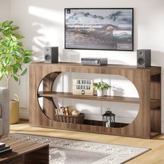 a living room with a large screen tv on top of a wooden entertainment center next to a potted plant