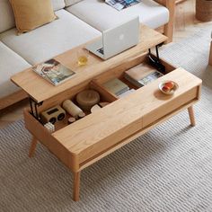 a living room with a couch, coffee table and laptop on top of the table