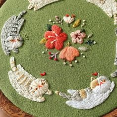 a close up of a circular rug with cats and flowers on the top, surrounded by beads