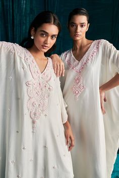 Ivory mul silk kaftan with geometric pattern yoke, contrast pink thread, sequin and cut dana embroidery. - Aza Fashions Summer Silk Kaftan With Intricate Embroidery, White Silk Kaftan For Festive Occasions, Festive White Kurta With Embroidered Neckline, White Dresses With Mirror Work, Cream Kaftan With Resham Embroidery For Festive Occasions, Cream Embroidered Kaftan For Eid, Traditional White Silk Kaftan, Cream Resham Embroidery Kaftan For Festive Occasions, Festive Cream Kaftan With Resham Embroidery