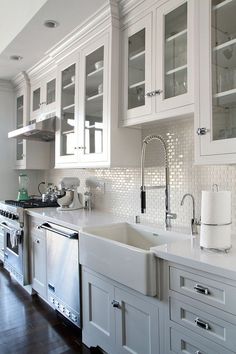 a kitchen with white cabinets and stainless steel appliances